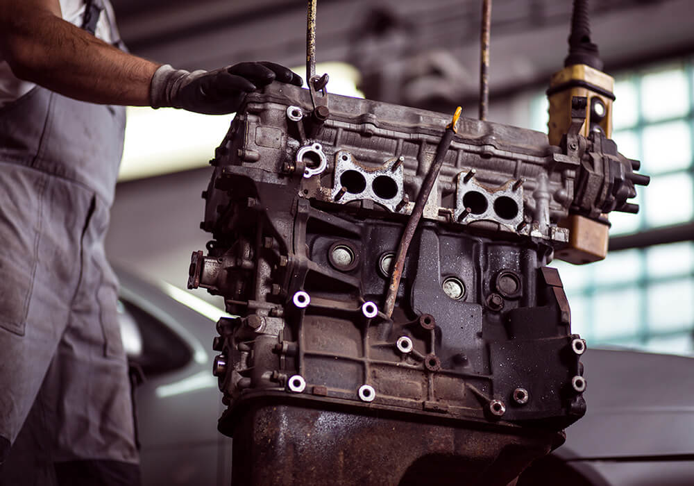 Complete engine overhaul service in Bonita Springs, FL featuring a rebuilt motor block suspended on a shop hoist