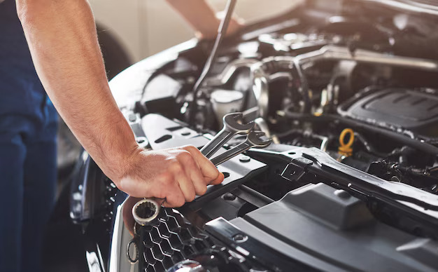 Close-up of a mechanic holding wrenches while preparing for engine repair service in Bonita Springs, FL