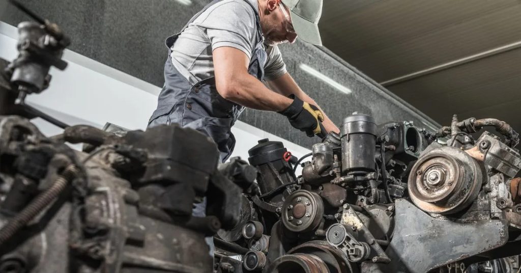 Certified auto mechanic repairing a disassembled engine block in Naples, FL